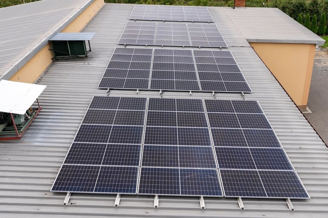 Multiple solar panels installed on a metal rooftop of a building.
