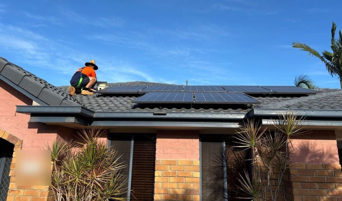 Evolved Solar installer working on the existing rooftop solar array at a Molendinar home