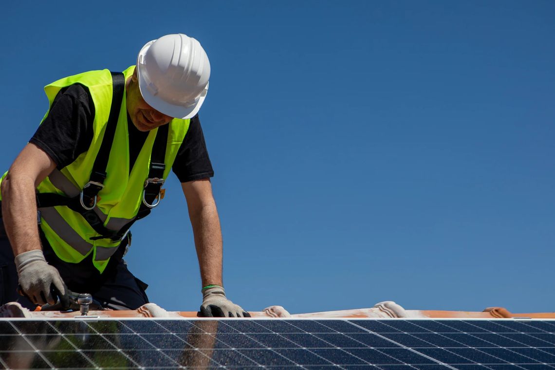 Solar electrician installing panels on Gold Coast home roof